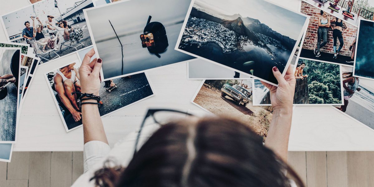 ragazza vista dall'alto all'interno di uno studio fotografico mentre seleziona alcune fotografie