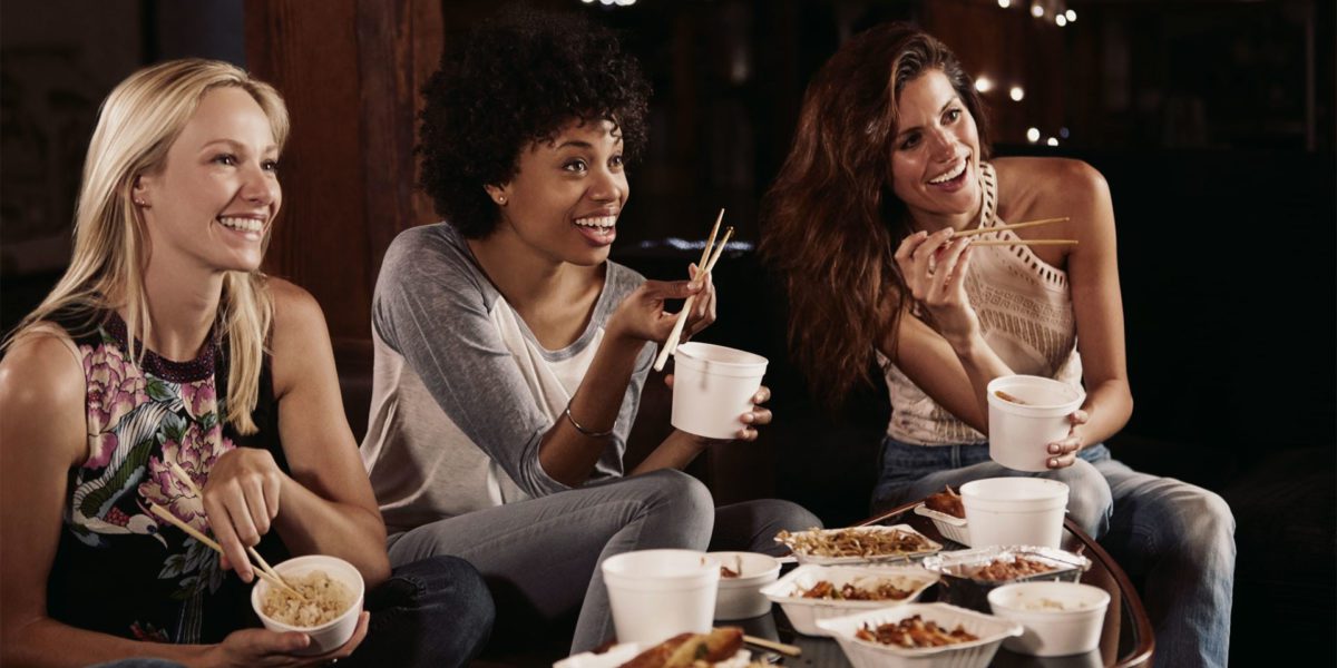 tre ragazze mangiano cibo cinese davanti alla tv